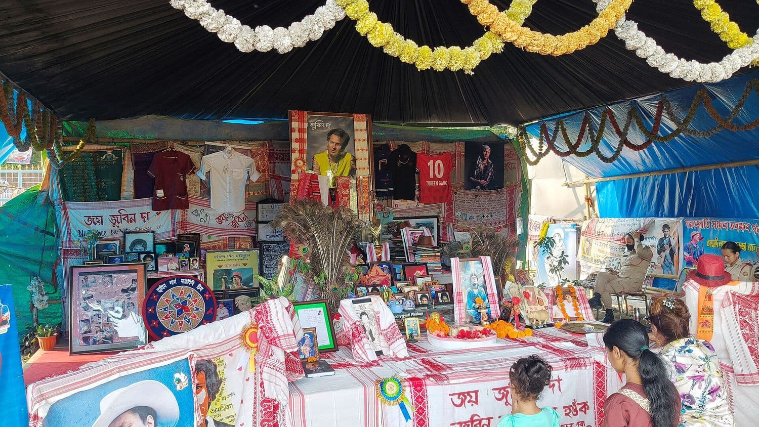 Photographs, gamosas and flowers offered by admirers near Zubeen Kshetra