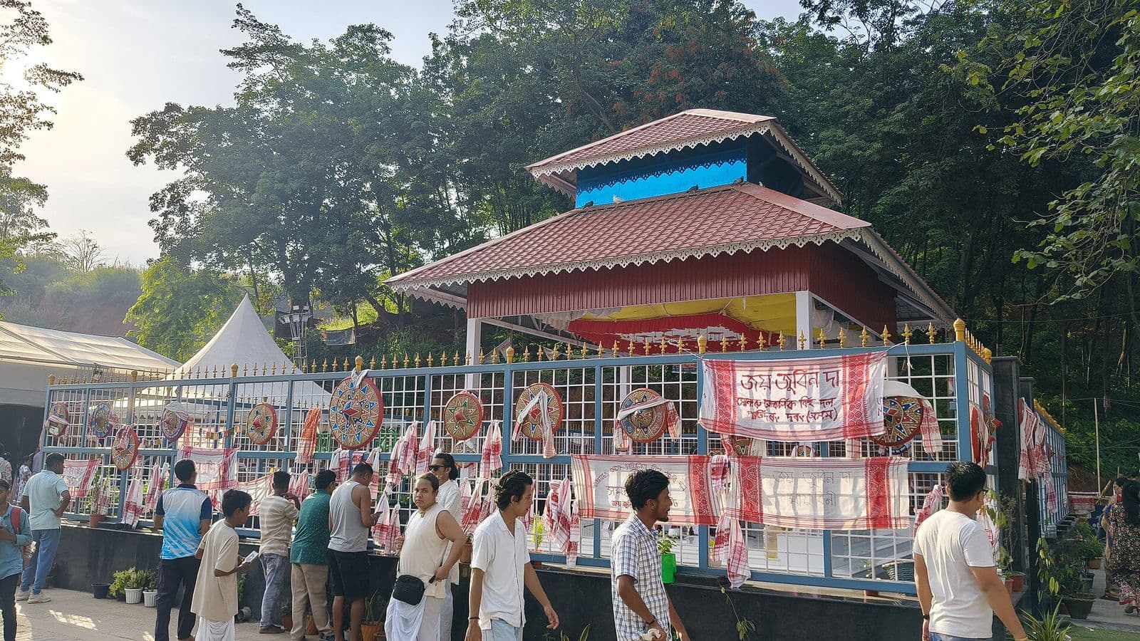 Visitors walking beside the fence of the memorial at Zubeen Kshetra, Sonapur