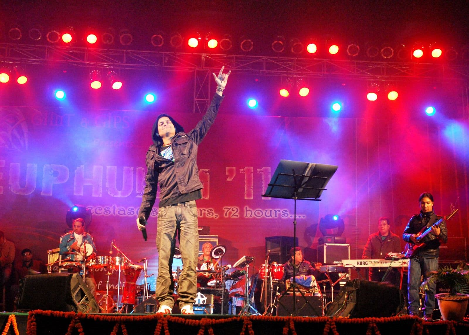 Zubeen Garg on a red and blue lit stage with his arm raised, 2011